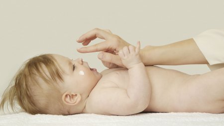Vaša koža - Beba - Mama nanosi kremu na bebu Vaša koža - Beba - Mama nanosi kremu na bebu